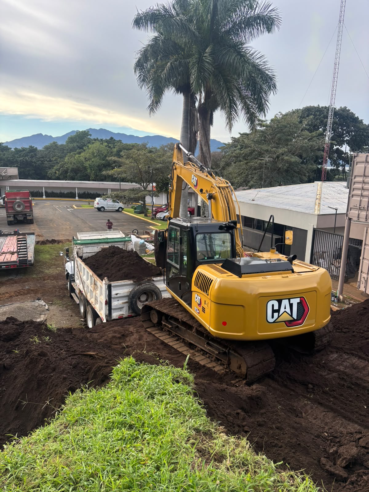 Excavadora CAT cargando tierra en vagoneta en obra de movimiento de tierra